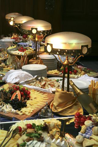 Table garnie d'assiettes empilées et de plats de nourriture divers.