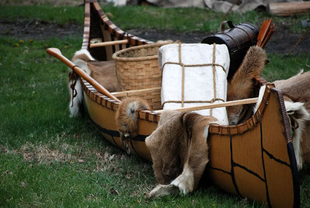 Canot ancestral déposé sur la terre ferme et chargé de fourrures et d'équipement de trappage.