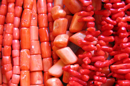 Ensemble de colliers en perles de corail rouges de différentes tailles.