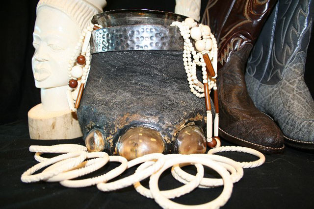 Various objects made from elephant anatomical parts: sculptures, ivory bracelets and necklaces, baby elephant foot made into a container, elephant skin boot.